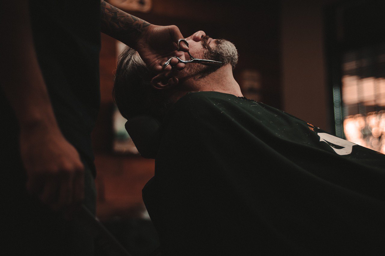 Cliente recebendo serviço no ambiente profissional da barbearia.